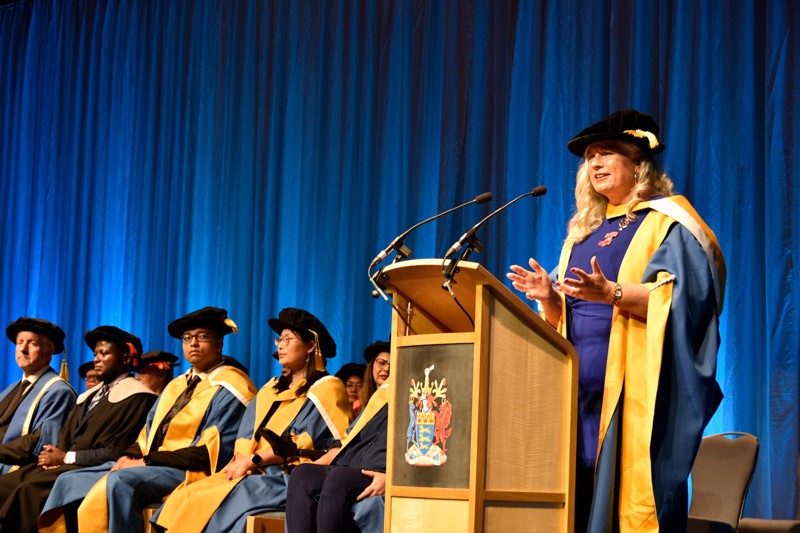 Alison in her ceremonial robes give a speech at a lecturn