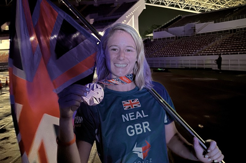 Becky holding a Union Flag and showing her medal to the camera