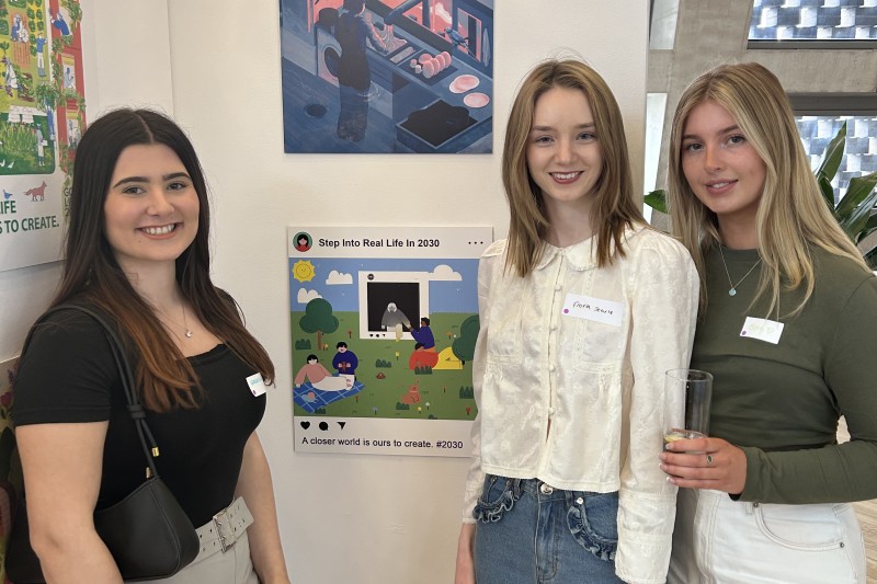 Gabriella, Beth and Fiona, standing by their artwork looking towards the camera