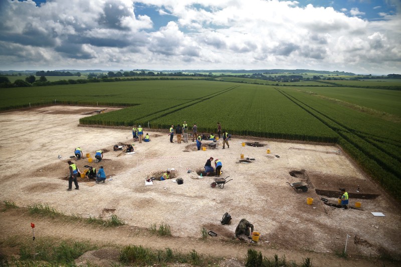 A landscape showing the excavation site with rural countryside fields in the background. 