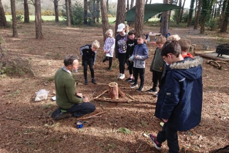 teacher and children learning in the forest