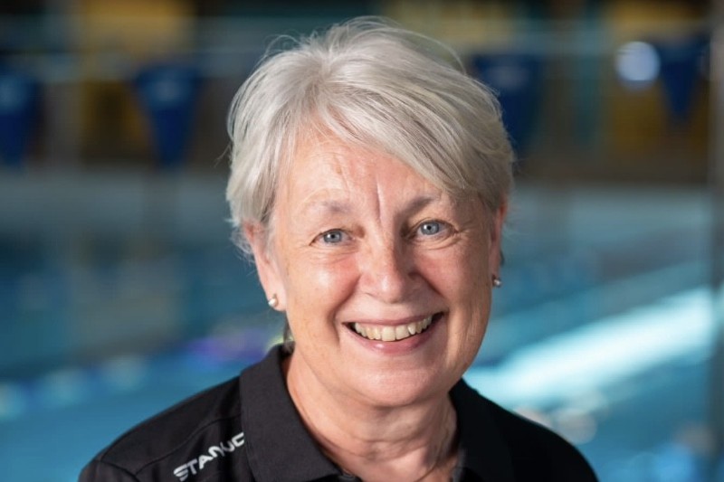 Jan Hutchings smiling in front of a swimming pool