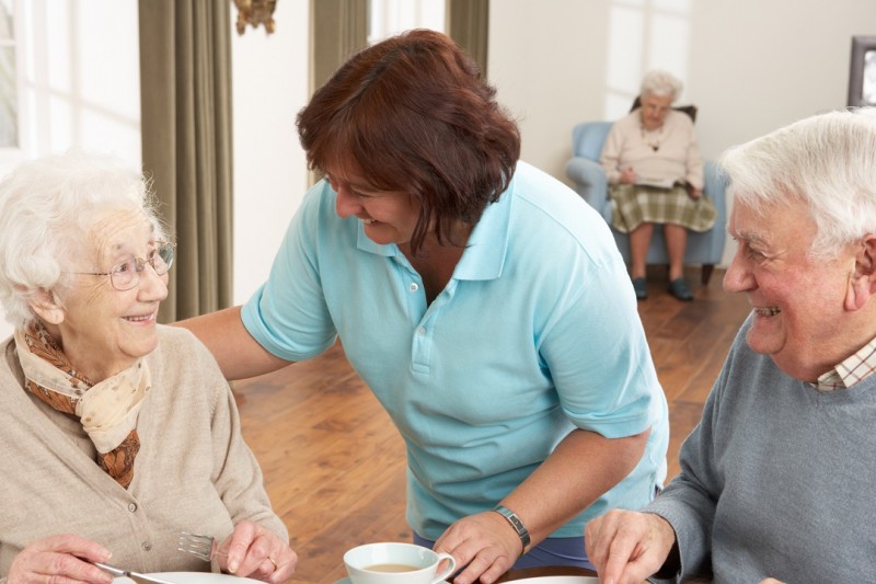 Older people served dinner by a carer