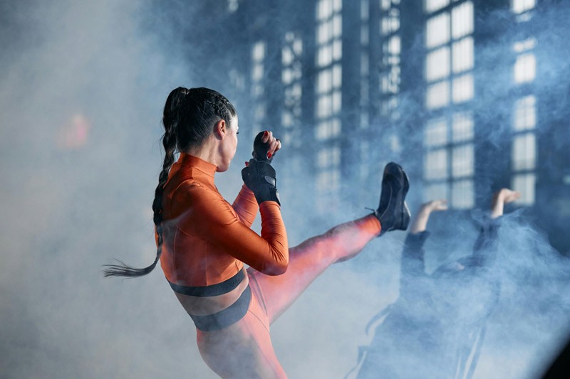 A woman kicking her opponent in a dramatic fight scene